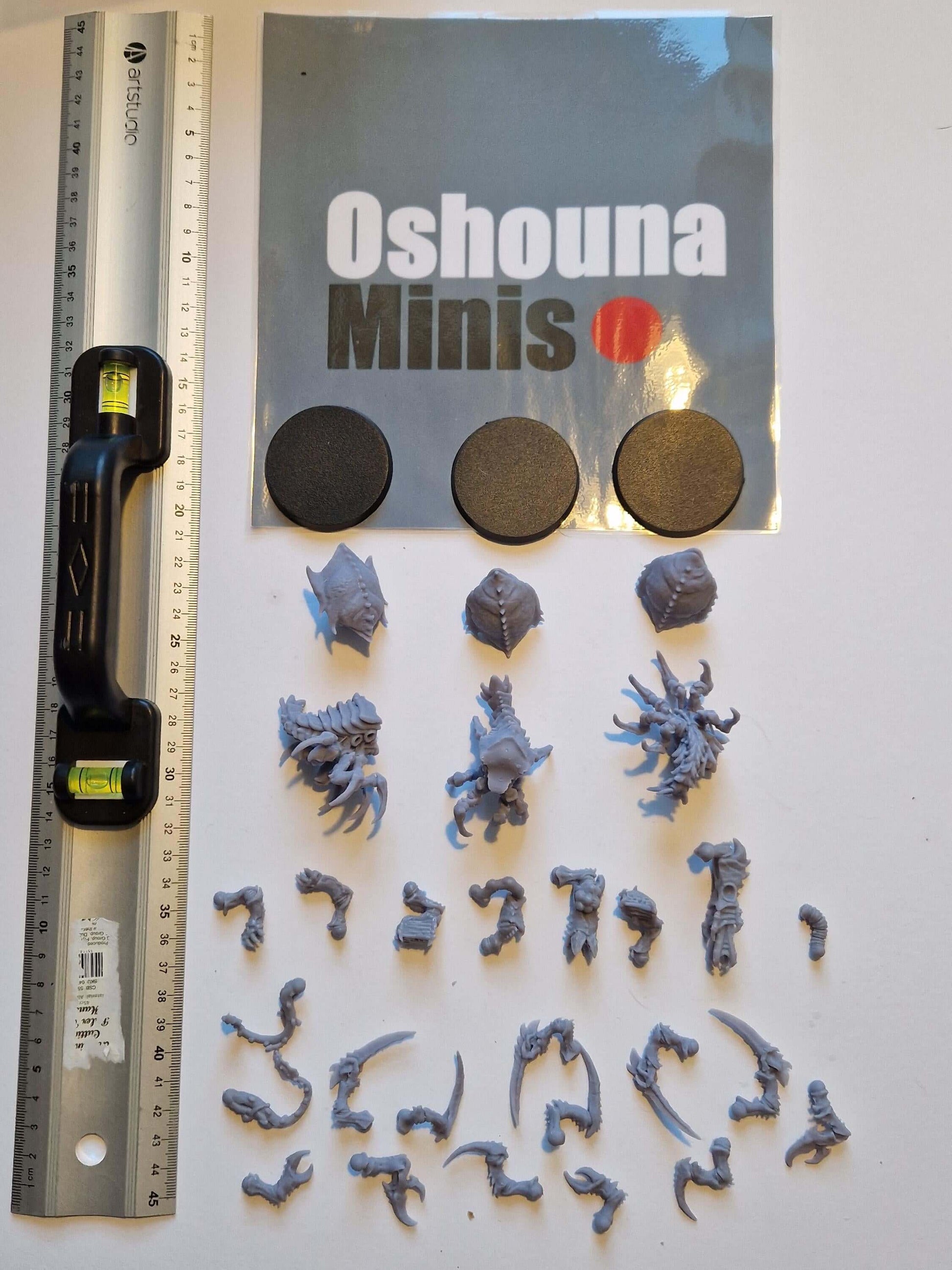 Oshouna Minis unpainted resin miniatures, hobby supplies including bases, ruler for scale, and assembly parts.